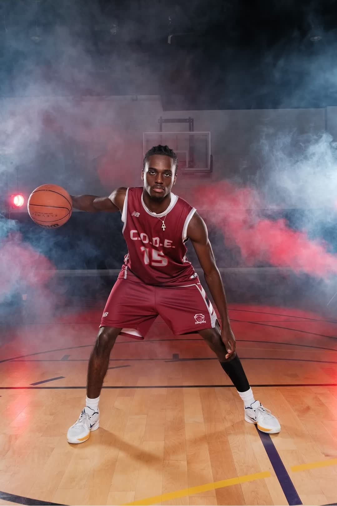 Daniel Igbokwe in his basketball uniform, holding a ball in a low stance
